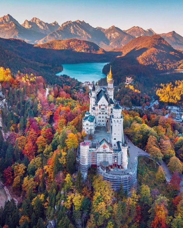 Een kasteel in de bergen gehuld in prachtige bomen legpuzzel online