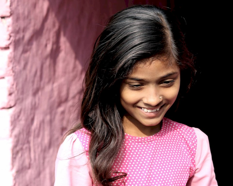 Menina sorridente em uma camisa rosa quebra-cabeças online