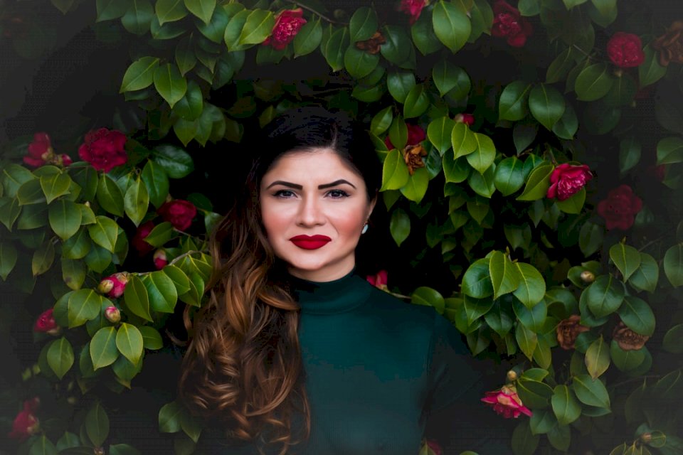 Женщина возле куста красного цветка онлайн-пазл