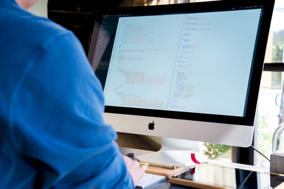 Desarrollador trabajando en un iMac rompecabezas en línea