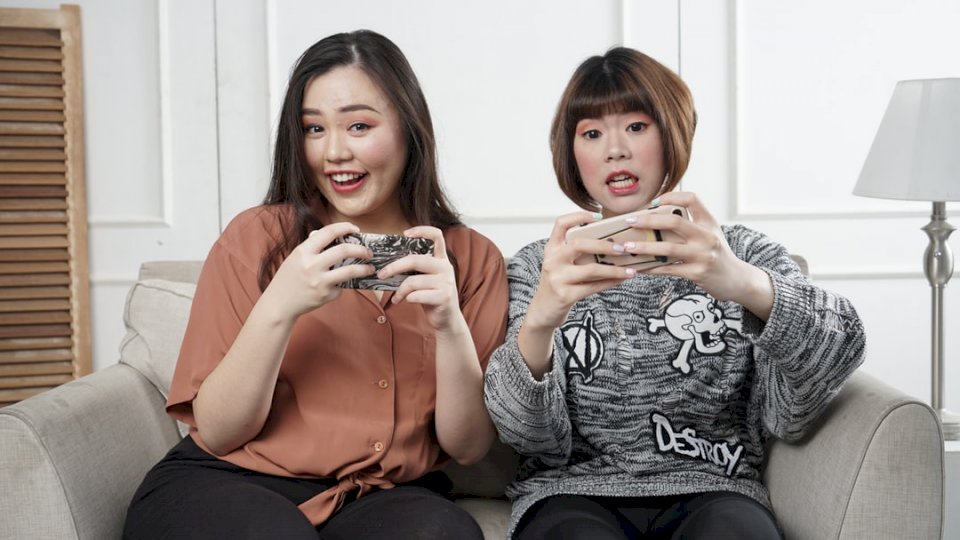 Mulher asiática, jogando um jogo móvel quebra-cabeças online