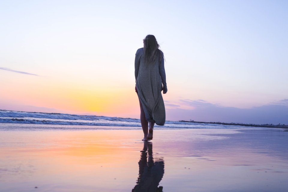 Donna che cammina sulla spiaggia di sabbia puzzle online