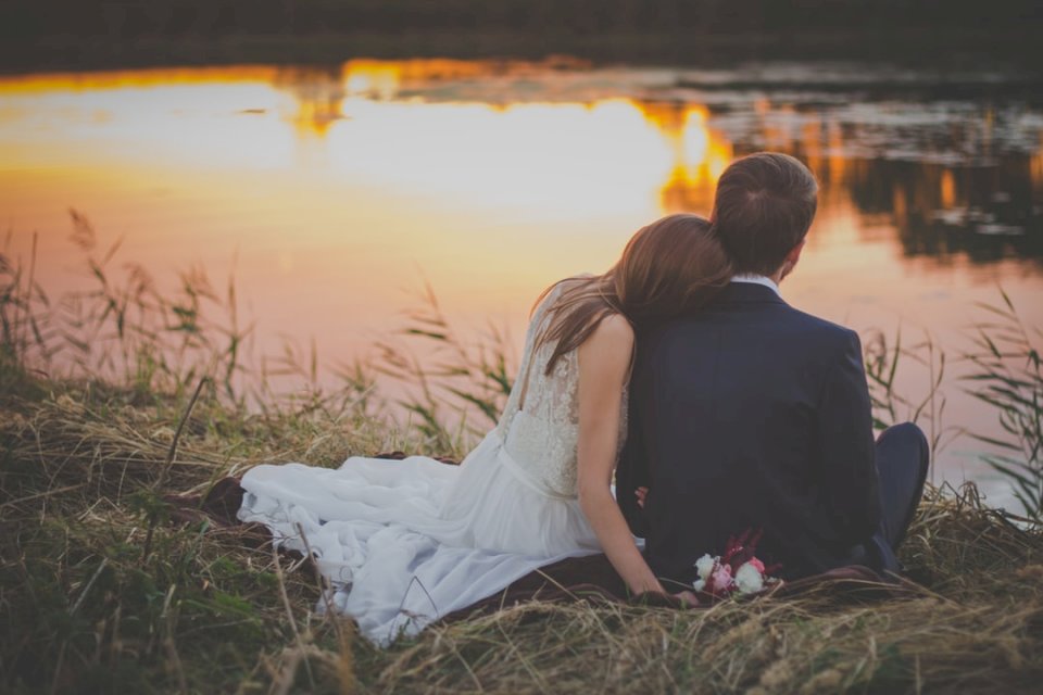 Bride and groom sit by pond jigsaw puzzle online