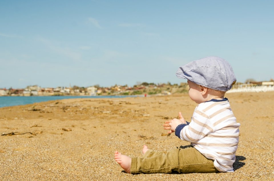 Een babyjongen zittend op het zand online puzzel