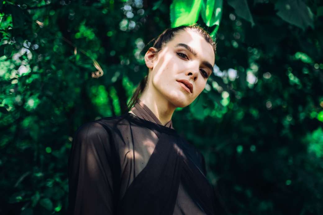 donna che indossa la parte superiore pura sotto la pianta a foglie verde puzzle online