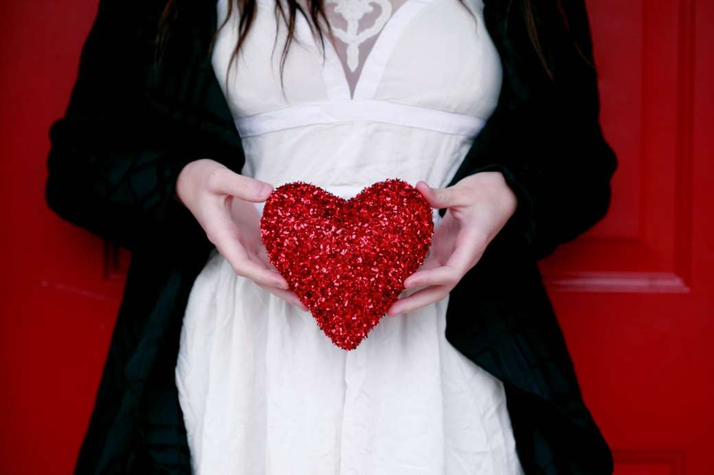женщины держат подушку с красным сердцем онлайн-пазл
