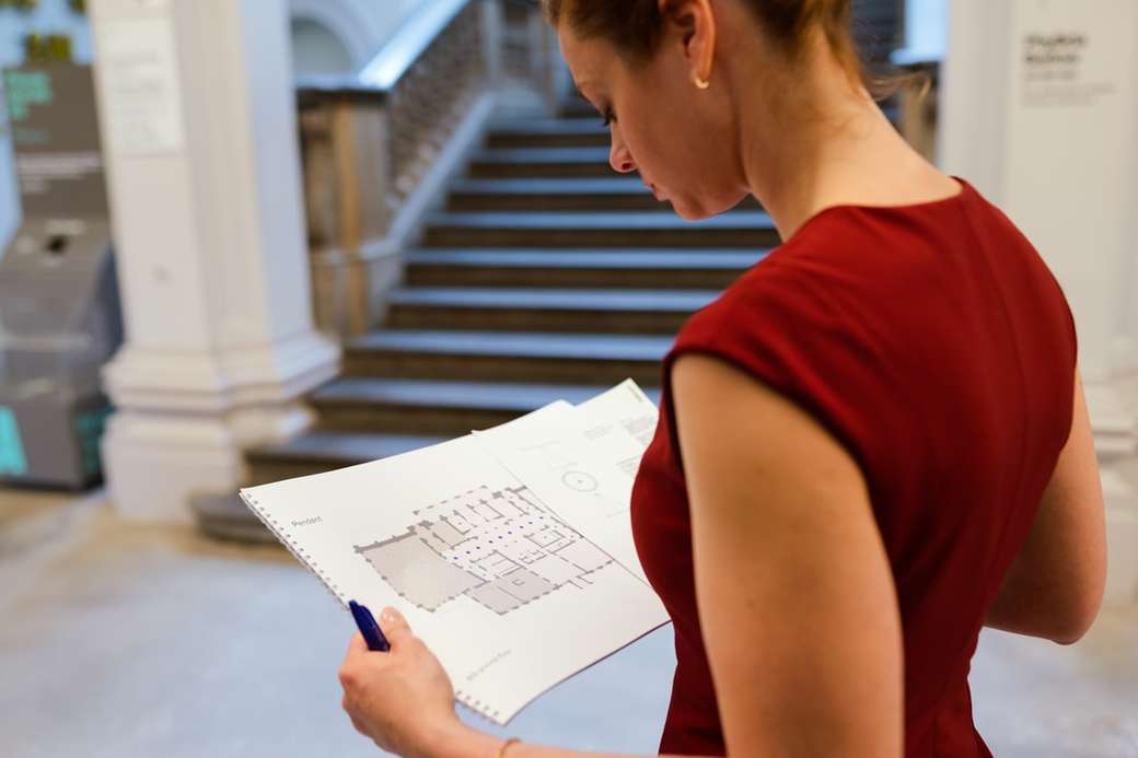 Femme en chemise sans manches rouge tenant du papier d'imprimante blanc puzzle en ligne
