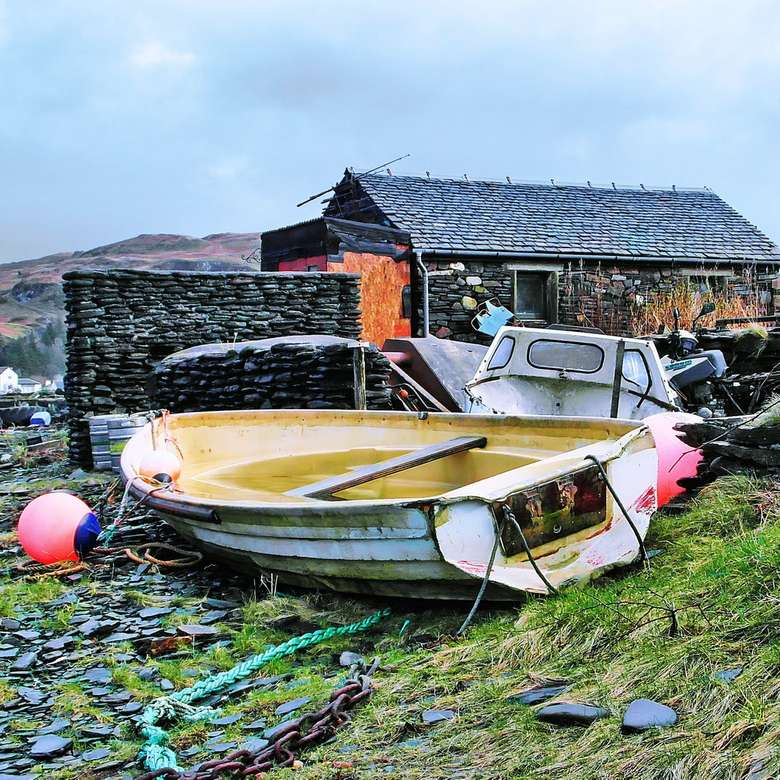 barco branco e marrom no rio perto de casas durante o dia quebra-cabeças online