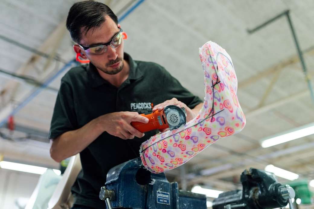 Un ingénieur technicien orthésiste masculin fait un plâtre de jambe personnalisé puzzle en ligne