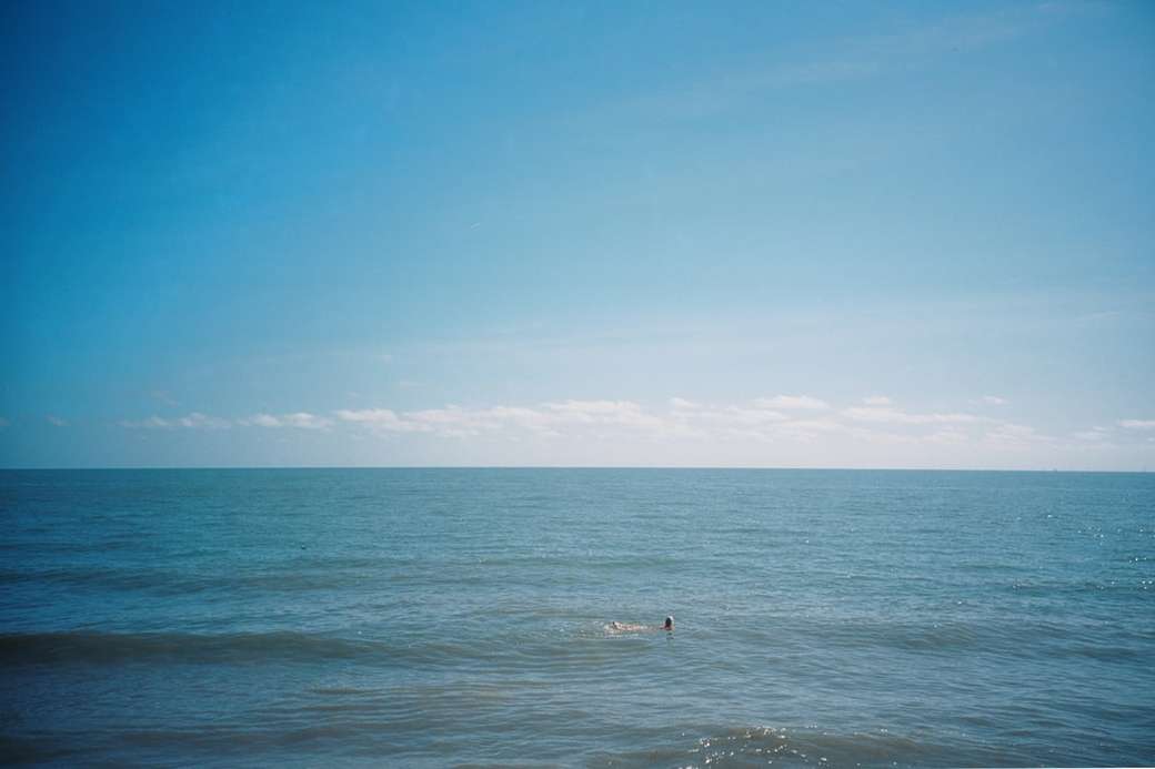 Persona navegando en el mar bajo el cielo azul durante el día rompecabezas en línea