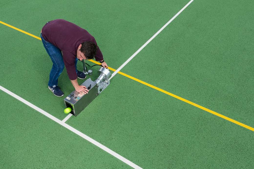 Ο άνδρας αθλητικός μηχανικός δοκιμάζει εξοπλισμό τένις online παζλ