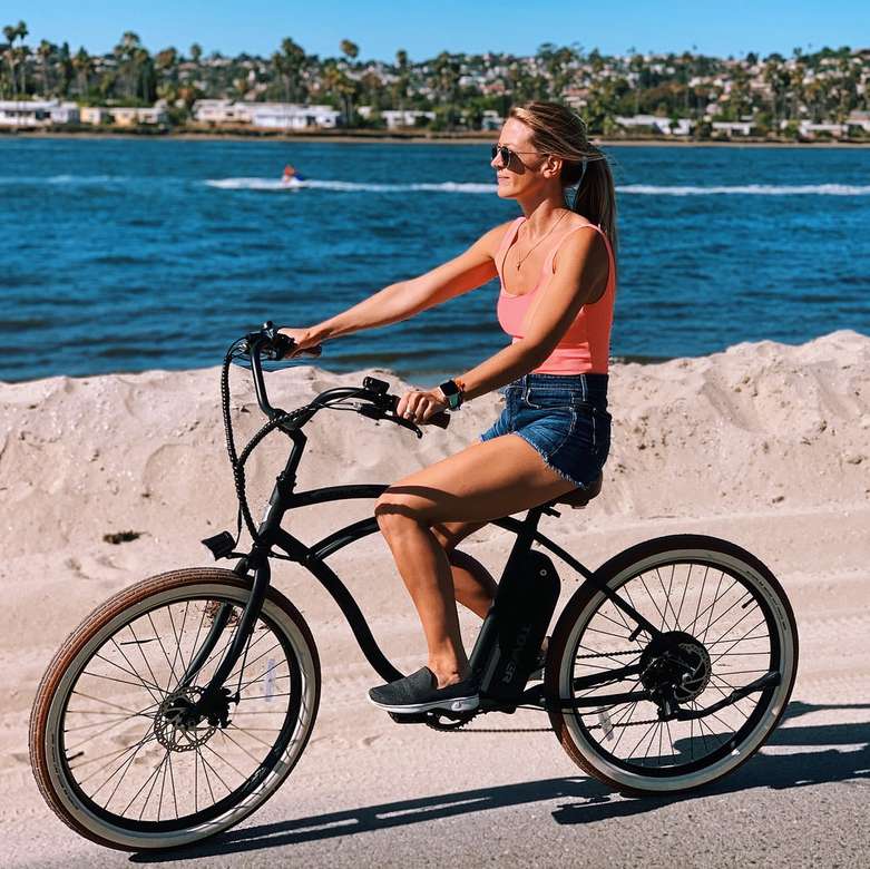 In sella a una bici elettrica Tower lungo la spiaggia. puzzle online