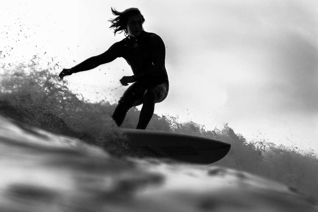фотографія у відтінках сірого, на якій людина катається на дошці для серфінгу онлайн пазл