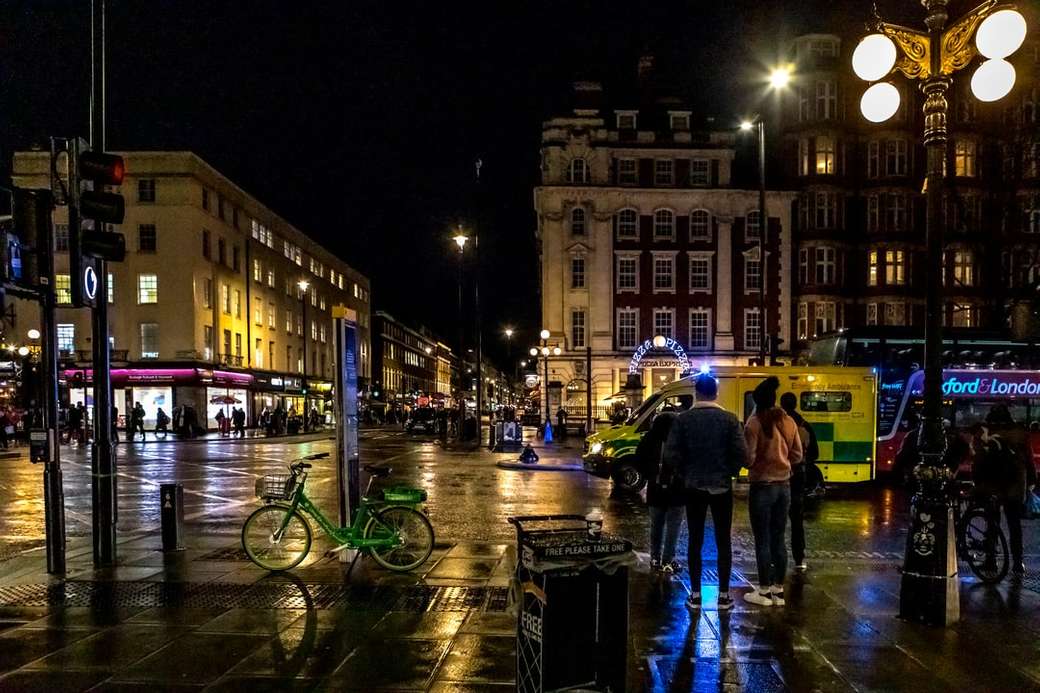 mensen lopen op de stoep in de buurt van gebouw tijdens de nacht legpuzzel online
