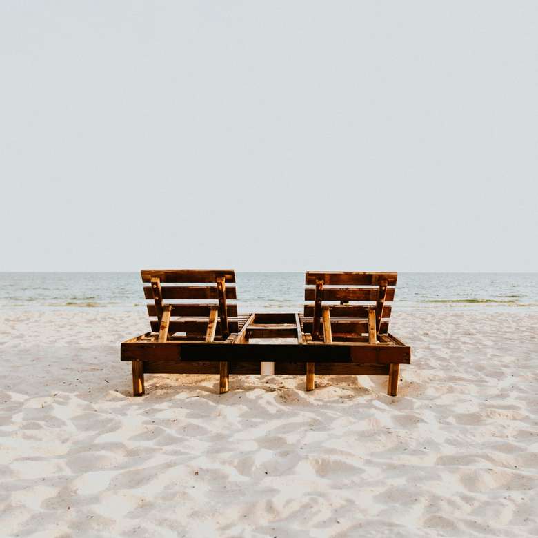 duas cadeiras de praia na areia perto do oceano quebra-cabeças online