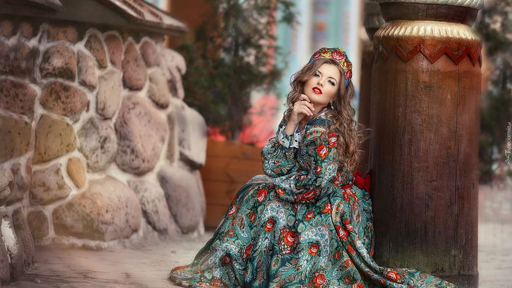 Μια γυναίκα σε ένα πολύχρωμο φόρεμα και κόμμωση παζλ online