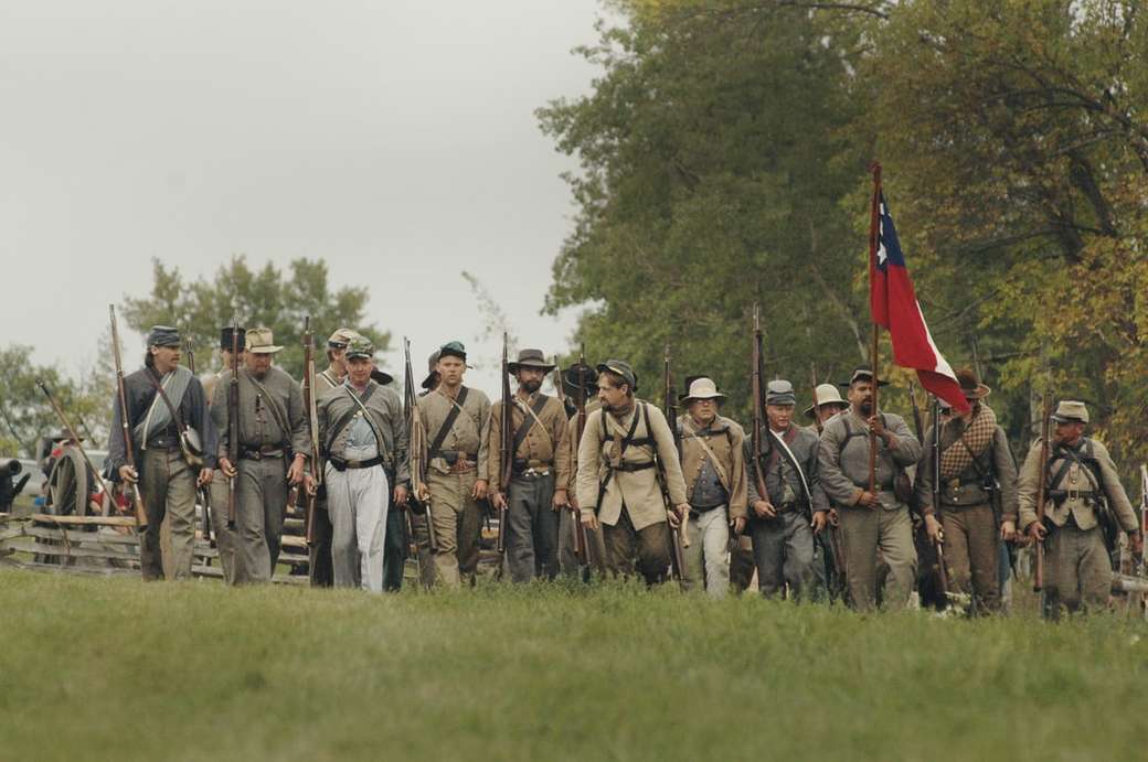 groupe d'hommes tenant un fusil de chasse et un drapeau puzzle en ligne
