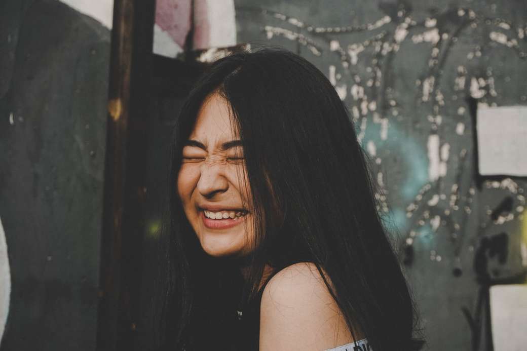 mujer sonriente mientras cierra sus ojos photo rompecabezas en línea