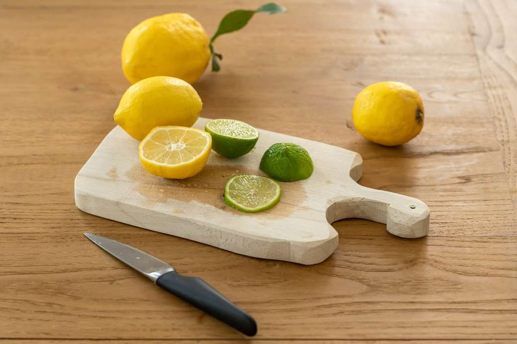 Zitrusfrucht mit Messer auf Schneidebrett Puzzlespiel online