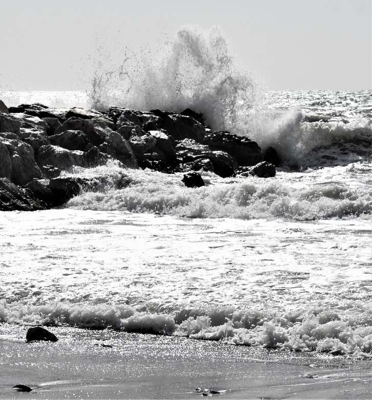 vlny oceánu narážející na kameny během dne skládačky online
