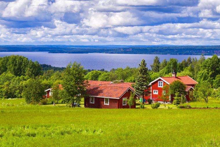 Maisons rouges au bord du lac en Suède puzzle en ligne