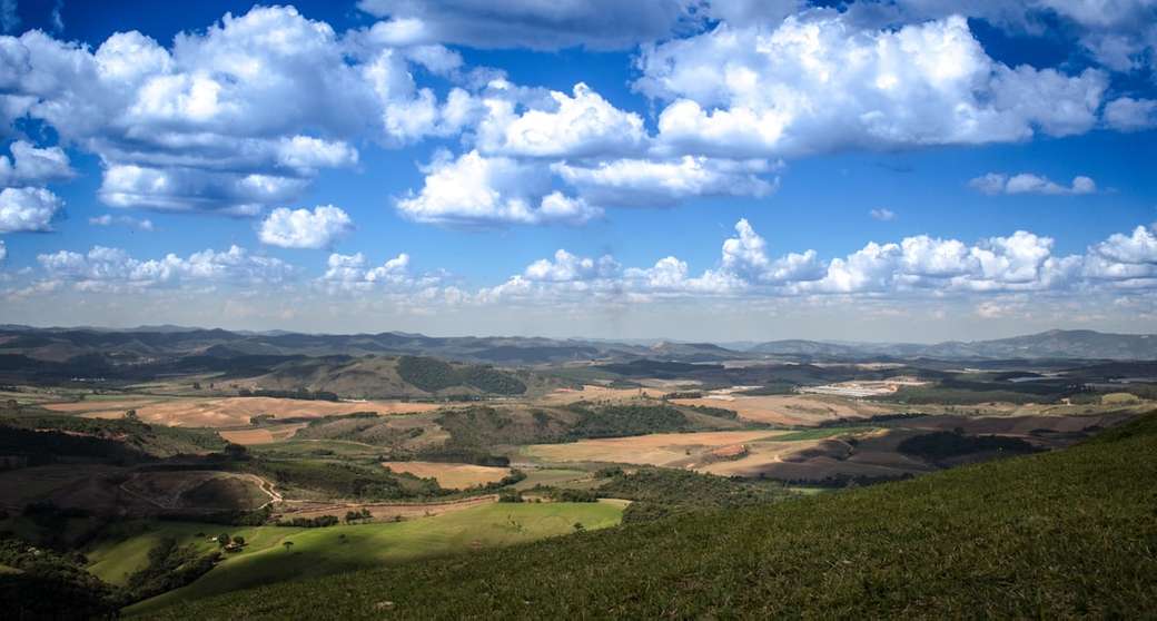 аерофотозйомка гір і поля під час хмарного неба пазл онлайн
