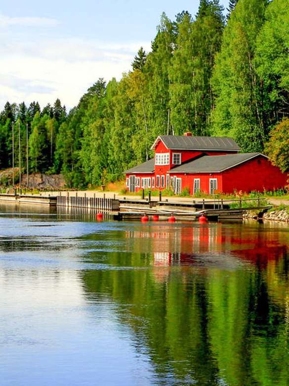 Maison en bois rouge au bord du lac en Finlande puzzle en ligne