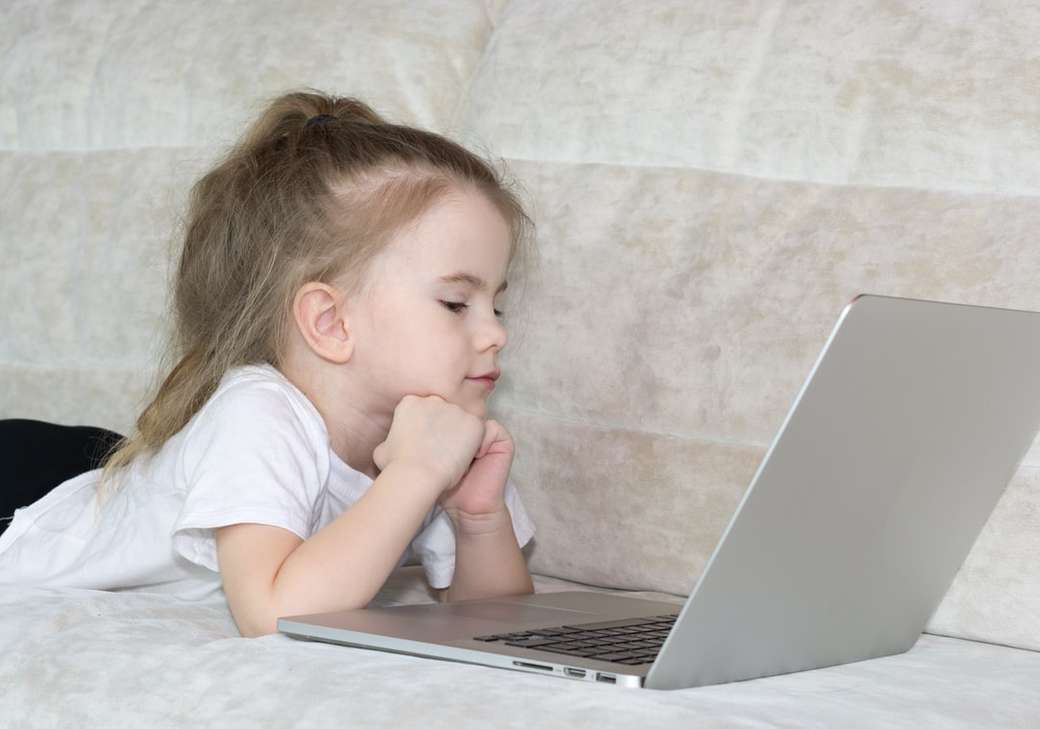 dívka v bílém tričku pomocí stříbrného přenosného počítače skládačky online