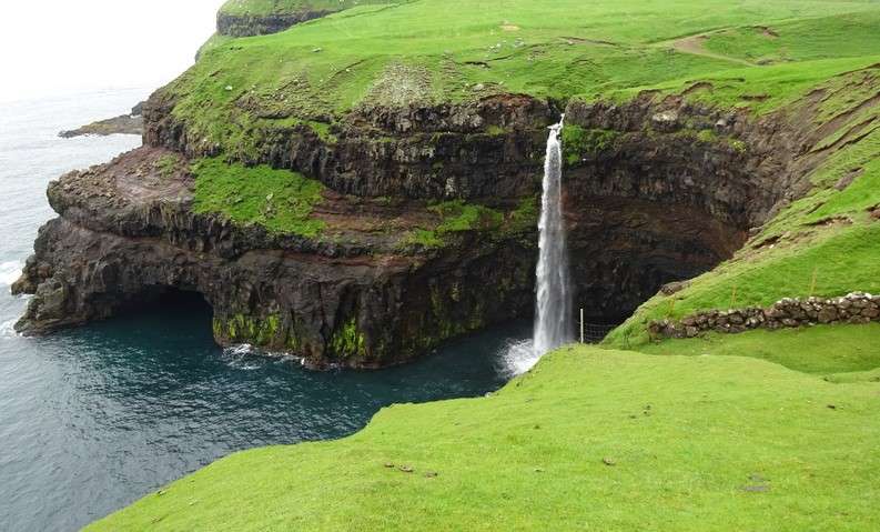 Крутой берег с водопадом Фарерские острова онлайн-пазл