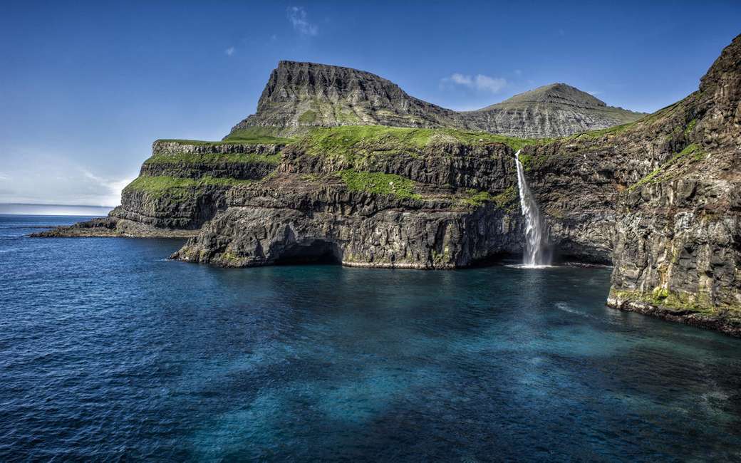 Costa escarpada con cascada Islas Feroe rompecabezas en línea