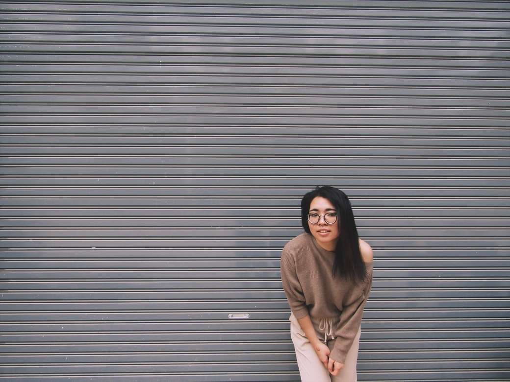 kvinna som lutar sig på grå garageport pussel på nätet