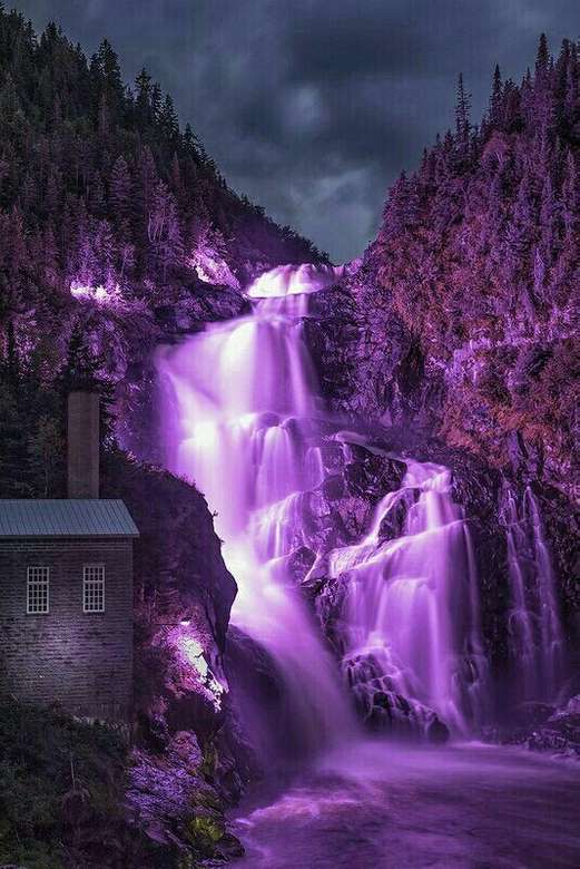 Фіолетовий водоспад з хатиною на скелях онлайн пазл