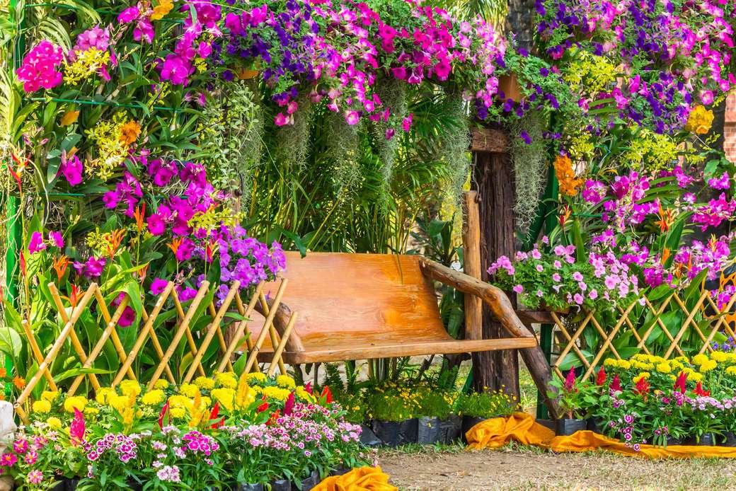 Hojnost květin na domě s lavičkou k odpočinku online puzzle