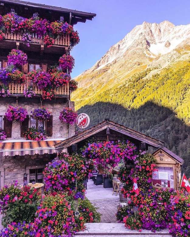Üppige Blumenfülle am Haus in der Schweiz Online-Puzzle
