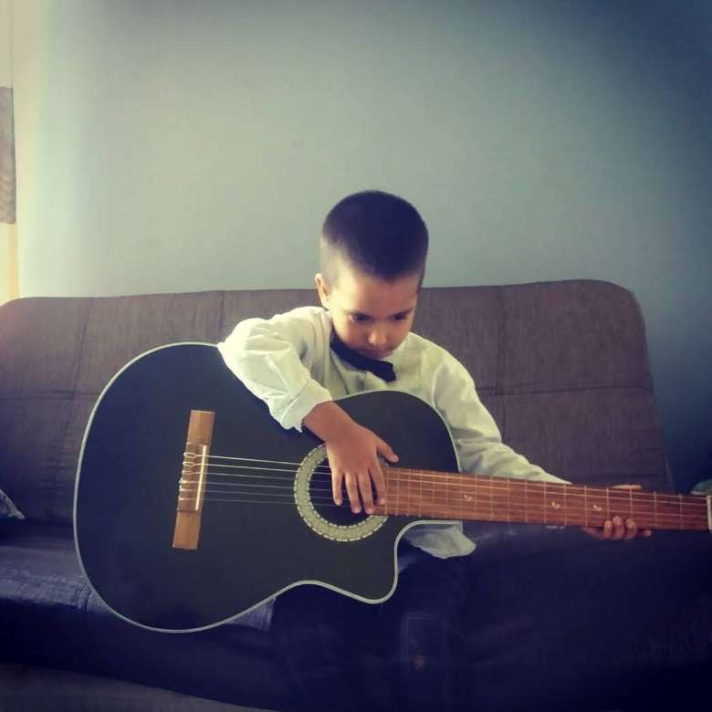 Guitare + enfant = victoire puzzle en ligne