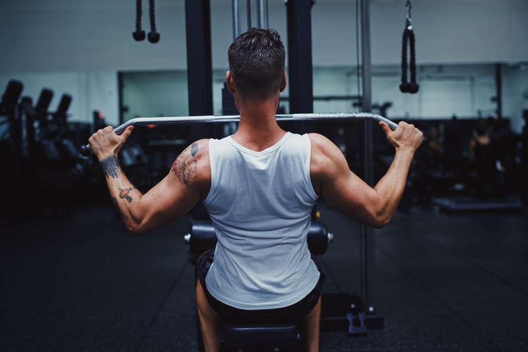 man in gray tank top and black shorts holding black barbell jigsaw puzzle online