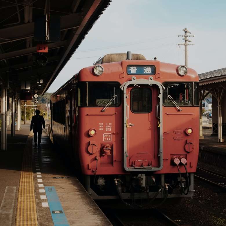 昼間の駅横の赤い電車 ジグソーパズルオンライン