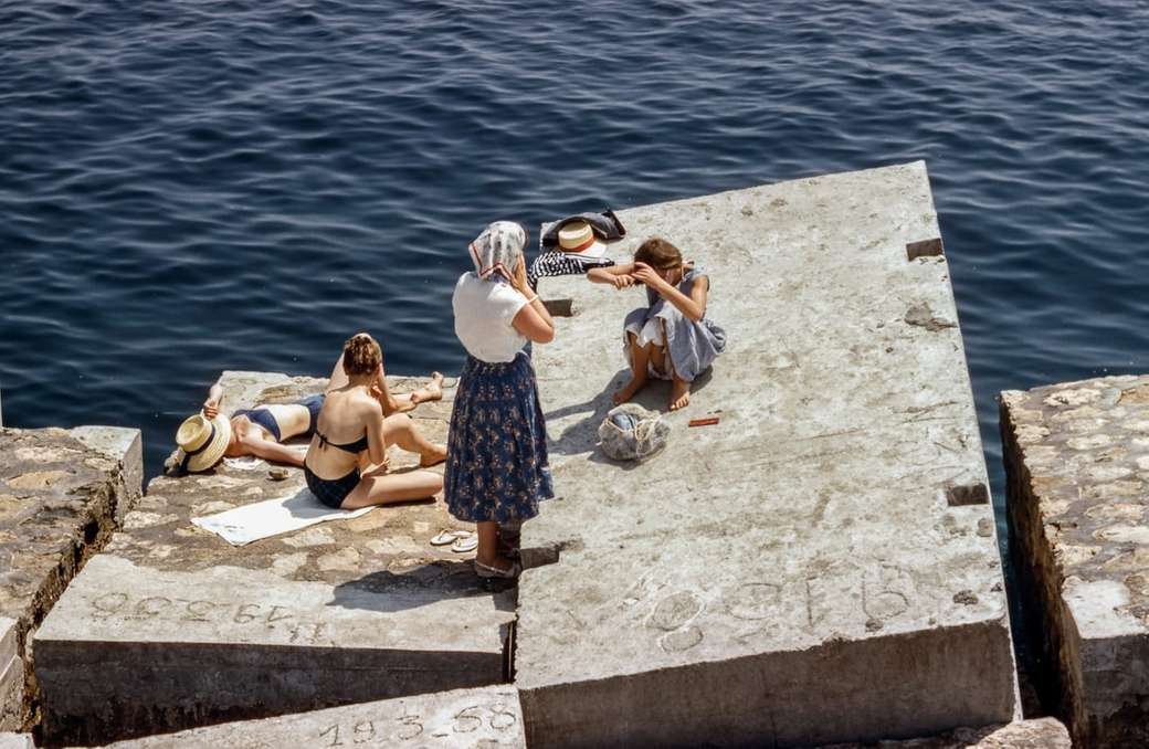 Γυναίκες που κάνουν ηλιοθεραπεία δίπλα στη θάλασσα παζλ online