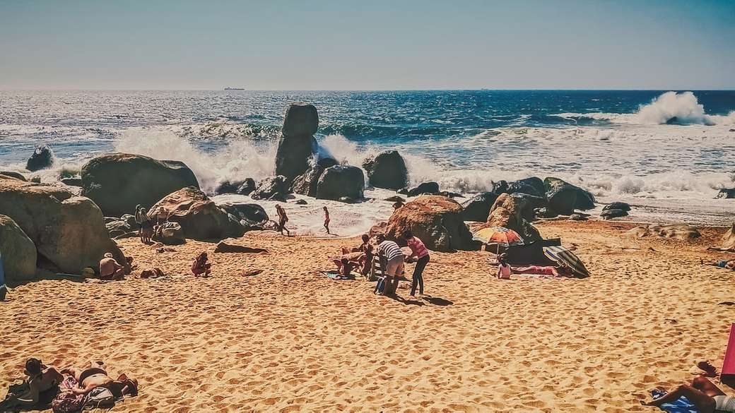 люди сидят на берегу пляжа в дневное время пазл онлайн