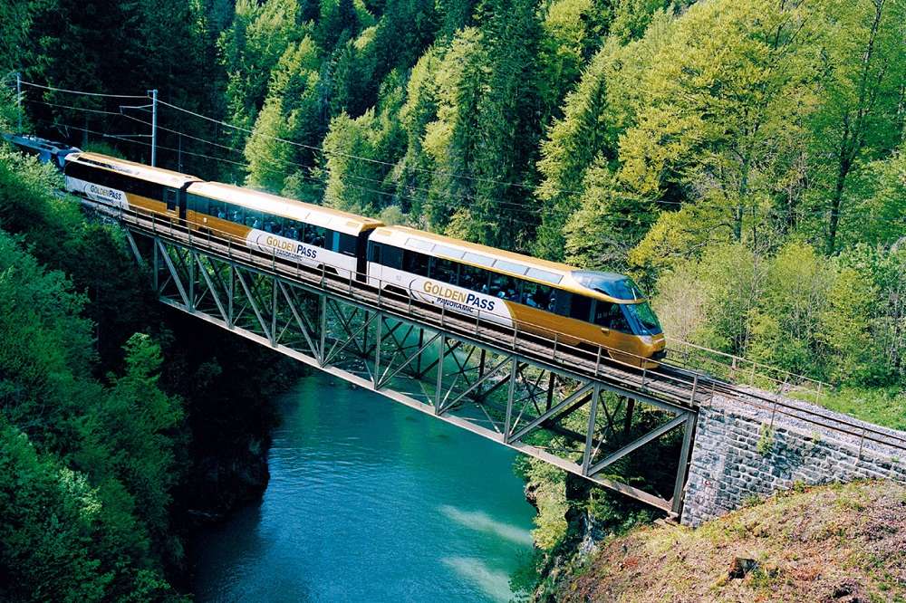 Ridande tåg i bergen vid bron Pussel online