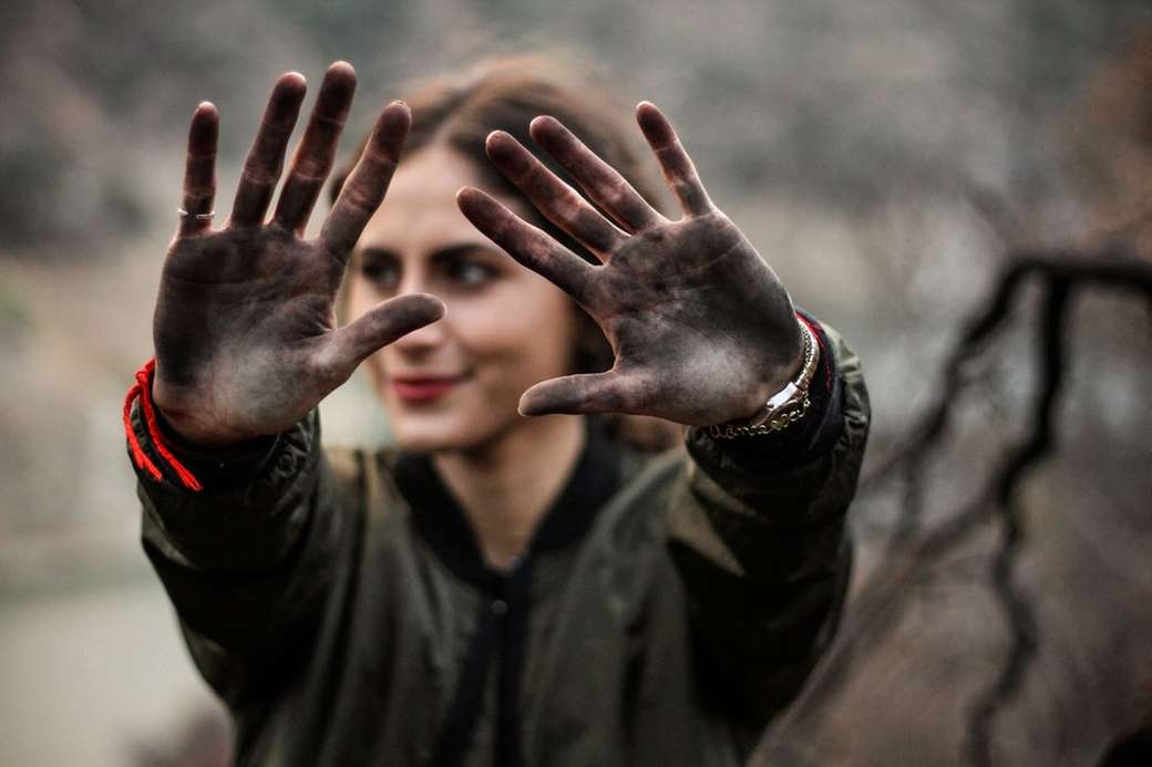 жена, показваща ръцете си с черна боя онлайн пъзел