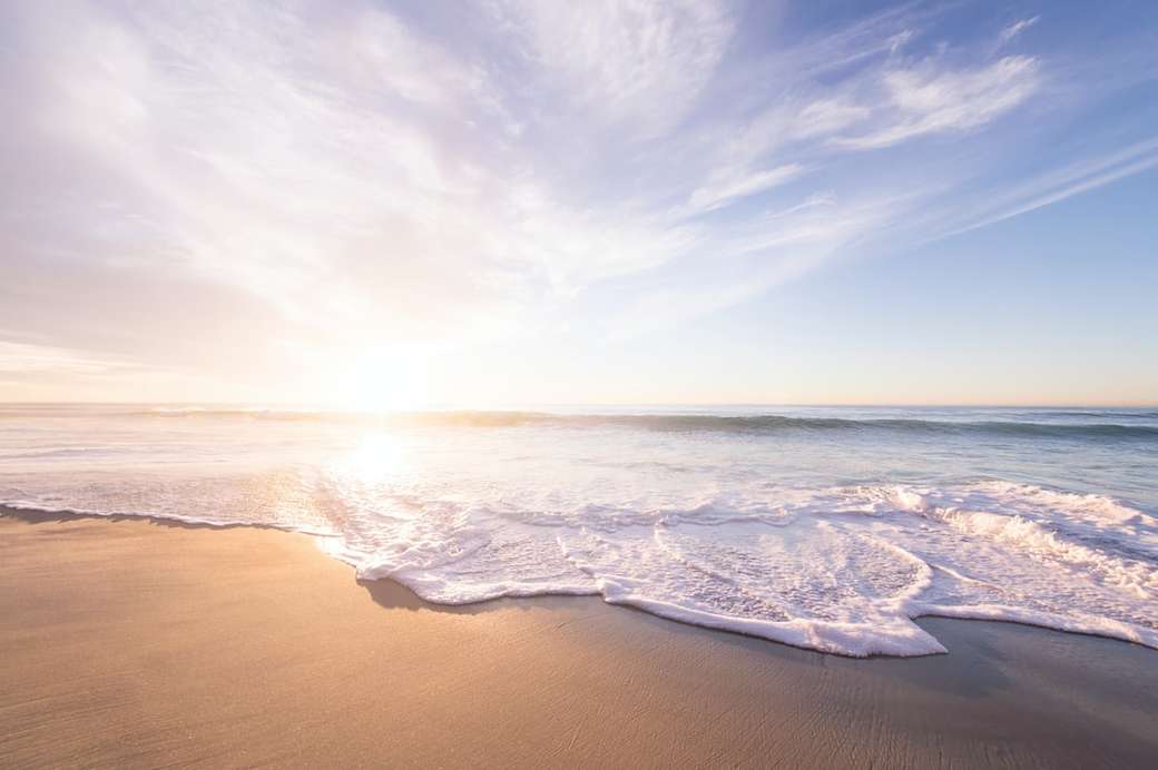 Ανατολή του ηλίου πάνω από μια αμμώδη παραλία παζλ online