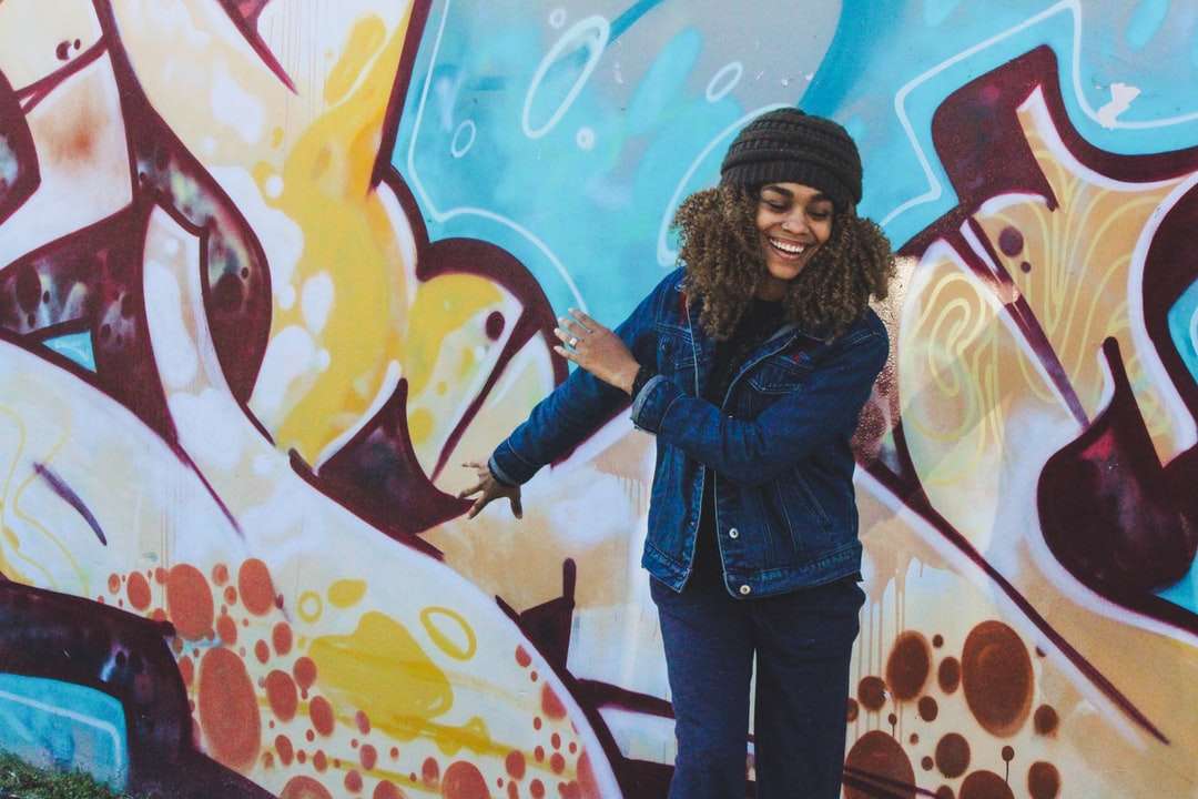 Mujer sonriendo frente a graffiti rompecabezas en línea