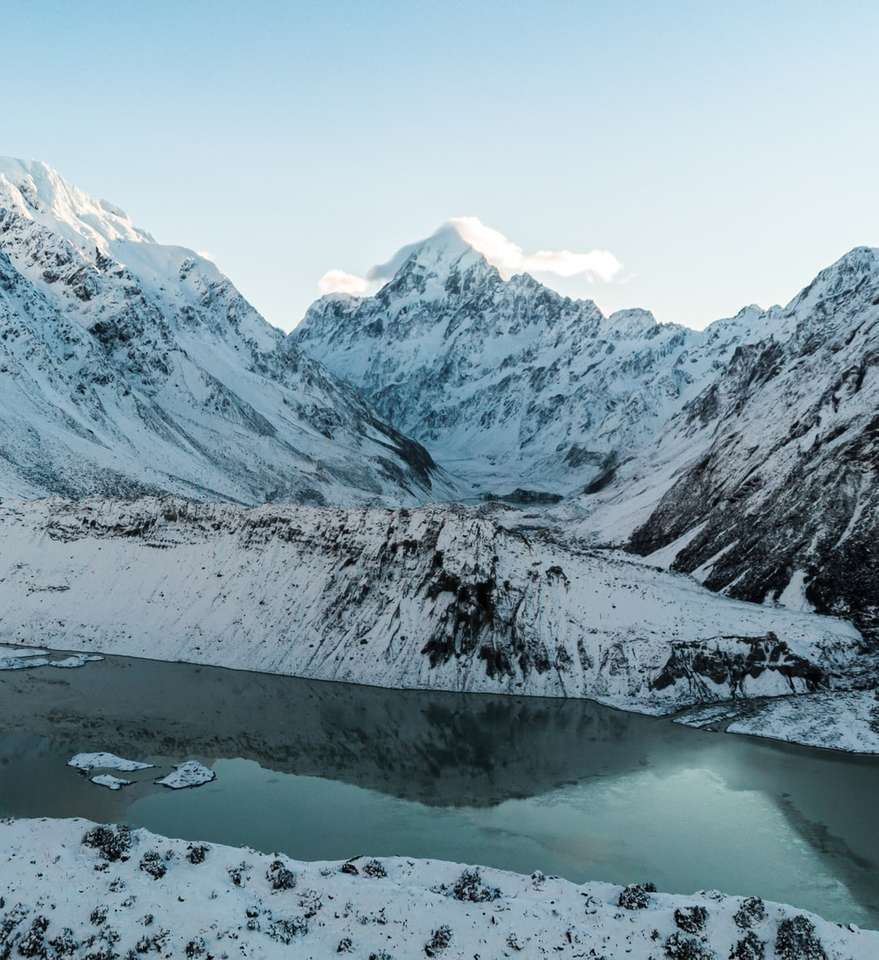 schneebedeckter Berg in der Nähe von Gewässern Puzzlespiel online