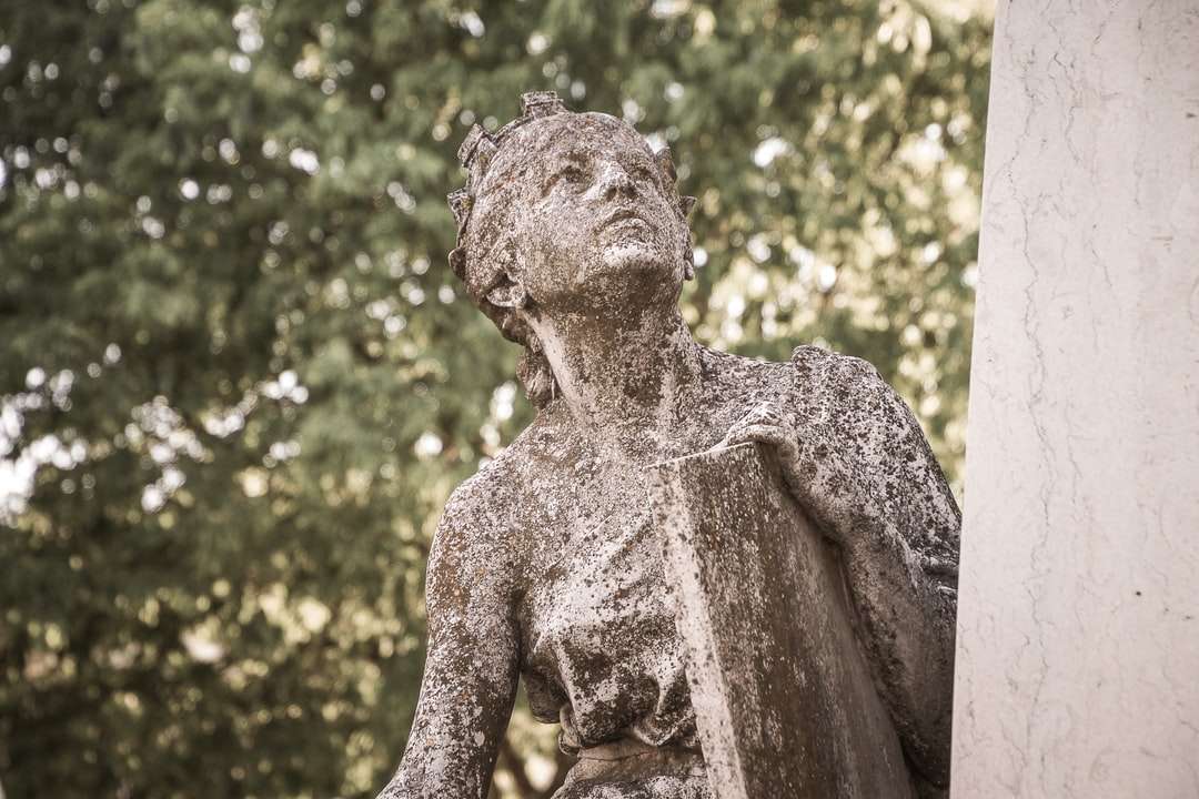 statua di cemento marrone vicino agli alberi verdi durante il giorno puzzle online
