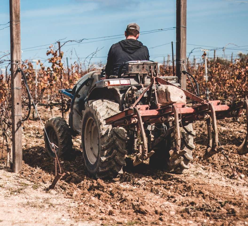 man in black jacket riding on red tractor online puzzle