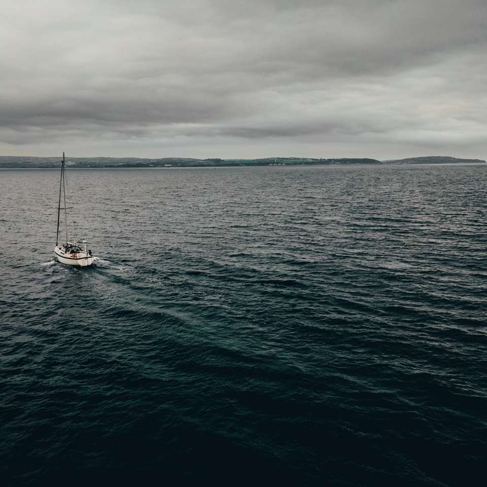 witte boot op zee onder bewolkte hemel overdag online puzzel