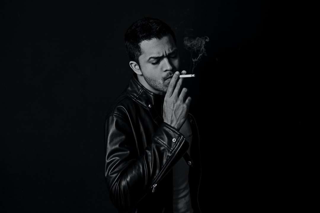 Foto en escala de grises del hombre fumando cigarrillos rompecabezas en línea