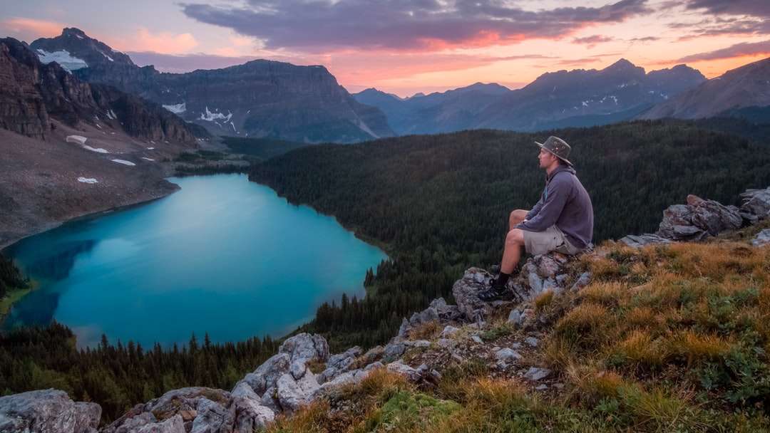 homem olhando para a montanha sentado na rocha puzzle online
