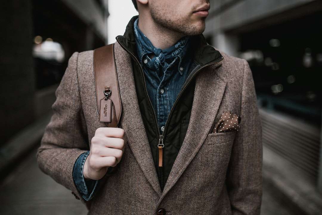 Hombre de chaqueta de traje marrón con mochila marrón rompecabezas en línea
